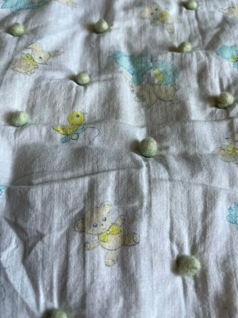 Vintage Style Baby Nursery Crib Quilt with Pom-Pom Accents and Animal Print